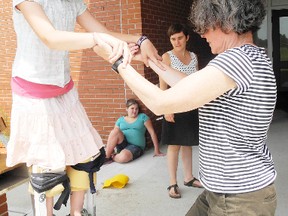 Anne Barber, artistic director with Shadowland Theatre, helps Elaina Petz, 10 of Port Rowan master the skill of stilt walking. (SARAH DOKTOR Simcoe Reformer)