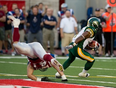 Shea Emry (left) falls as Hugh Charles runs the ball during the first half of the game between the Montreal Alouettes and the Edmonton Eskimos, at the Percival Molson Stadium in Montreal, QC, on July 25, 2013. The Eskimos lost 32-27 to the Alouettes. PIERRE-PAUL POULIN/LE JOURNAL DE MONTREAL/AGENCE QMI