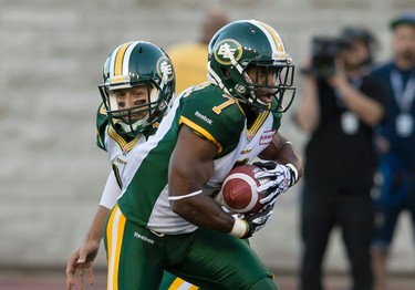 Edmonton quarterback Mike Reilly hands off to Hugh Charles during the first half of the game between the Montreal Alouettes and the Edmonton Eskimos, at the Percival Molson Stadium in Montreal, QC, on July 25, 2013. The Eskimos lost 32-27 to the Alouettes. PIERRE-PAUL POULIN/LE JOURNAL DE MONTREAL/AGENCE QMI