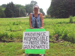 Rowena Williams stands with a protest sign next to a lot on George St. in Port Stanley on Tuesday, July 23, 2013 . The lot is one of three zoned for new residential developments but Williams believed the lots are on a wetland and home to about 10 endangered species. Ben Forrest/QMI Agency/Times-Journal