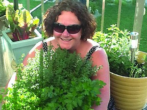 Jill Allen and her organic herbs including thyme, basil, oregano, parsley, cilantro and sage, all grown on her deck. This is one of the photographs received for the Grow Local Food Contest.