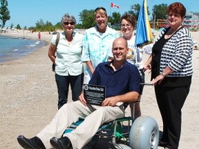 Residents and visitors alike can enjoy using a beach and lake accessible wheelchair donated by the Kincardine Rotary Club for Station Beach. L-R: Ruth Mahood of the Kincardine Accessibility Committee, Councillor Maureen Couture on behalf of Mayor Larry Kraemer, Kincardine Rotary Club member Jennifer White and Janet Haines on behalf of Lisa Thompson show off the new chair while MP for Huron-Bruce Ben Lobb tried it out on Station Beach on July 25, 2013.  (ALANNA RICE/KINCARDINE NEWS)