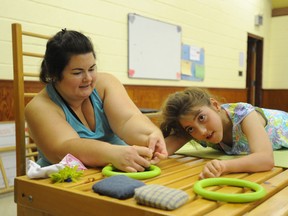 Michelle Brown helps her daughter Olivia grasp rings at a summer camp in Sarnia, Ont. Tuesday, July 23, 2013. The 11-year-old Sarnia girl who has cerebral palsy is participating in the Southwestern Ontario Optimist Conductive Education program to help strengthen her motor skills.  (BARBARA SIMPSON, The Observer)
