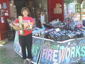 Linda J. Bonne holds samples of fireworks available at her retail outlet, Powerhouse Fireworks Co.