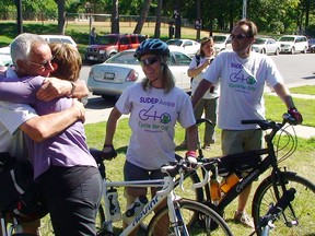 Wendy Tobin and Paul Jeffs, both parents who have lost children to Sudden Unexpected Death from Epilepsy (SUDEP), hug each other outside the epilepsy resource centre Friday morning. Jeffs is part of a group riding from Montreal to Kingston to raise money and awareness about SUDEP. Tobin's daughter Chelsea died from SUDEP last May. The bike ride is in memory of Jeffs' daughter Olivia Mullin, who died from SUDEP in 2007.                 
Elliot Ferguson The Whig-Standard