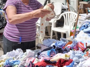 Ilene Yanchuk sorts through baby clothes donated to a huge fundraising garage sale held across from Youth for Christ Portage on Lorne Avenue Friday. (CLARISE KLASSEN/PORTAGE DAILY GRAPHIC/QMI AGENCY)