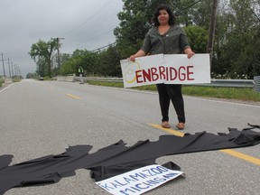 Vanessa Gray, of Aamjiwnaang and Sarnia Against Pipelines, recreated the Kalamazoo River oil spill during a LaSalle Line demonstration Saturday. ASAP members held the demonstration to draw attention to the spill caused by the rupture of a portion of Enbridge Line 6B. The group is lobbying against the reversal of Enbridge Line 9, which they fear could have similar consequences.