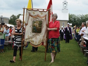 RYAN PAULSEN ryan.paulsen@sunmedia.ca
Bardella Kelly, left, and Anna Schroeder, long-time volunteers and pilgrims to the Shrine of St. Ann, help lead the procession at the beginning of Sunday's 11 a.m. Mass at the shrine in Cormac. For more community photos please visit our website photo gallery at www.thedailyobserver.ca.