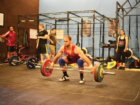 RYAN PAULSEN ryan.paulsen@sunmedia.ca
Tim Enfield demonstrates how to perform the Olympic style "snatch" lift with 105 kilograms of weight during Sunday afternoon's weightlifting demonstration for Kanama High Performance North, held at Crossfit Poise on Forest Lea Road. For more community photos please visit our website photo gallery at www.thedailyobserver.ca.