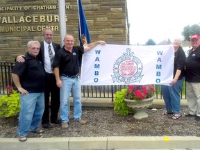 Government officials and WAMBO organizers hoist the WAMBO flag at the Wallaceburg Service Centre on Monday. They also announced that the festival will be receiving an Ontario Trillium Foundation grant for $40,400 to purchase equipment. (DAVID GOUGH, QMI Agency)