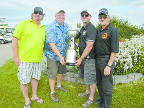 Fire Chief Randy Schroeder presents the Messy Cup to three members of the Barrhead foursome who placed first in the annual fundraising Mayerthorpe Emergency Services Society golf tournament held at the Mayerthorpe Golf Course on Friday, July 26. The group are, from right, Karl Baker, a retired firefighter, Schroeder, Capt Chad Hansen. and firefighter Gord Stoby. The fourth team member who was absent when the photo was taken is Lieut. Adam Graham.