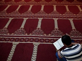 A Muslim faithful reads the Koran inside a makeshift mosque during prayers in the holy month of Ramadan.