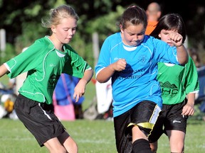 Emma Beute, left, of NHC Roofing & Exteriors tries to take the ball from Alexis Konstantinou of Renaissance Personnel during a Chatham Youth Soccer Association girls under-10 game Monday behind the Chatham-Kent courthouse. (MARK MALONE/The Daily News)