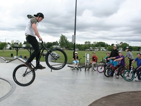 Sean Watson of Mud, Sweat and Gears demonstrates a bike trick to clinic participants July 27 at the 4-S Skatepark in Drayton Valley. Watson came from Sherwood Park to show local youth some new moves on their bikes and skateboards and have a fun time trying them out with their friends.