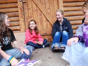 Rylee Sidoruk (left), 9, Paige Klassen, 10, and Tristan Campbell, 10, (far right) share stories with their camp counsellor Allyson Reichelt, 20, at Camp Wapiti on Monday. As a mentor to younger campers, Reichelt said she makes it a point to build a relationship with her group. “We’re able to be more interactive with the kids than teachers would be at school,” she said. (Caryn Ceolin/Daily Herald-Tribune)