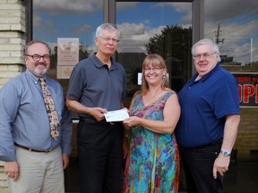 Jack McNiven of Bethany United Church in Shedden hands a cheque to Inn Out of the Cold St. Thomas-Elgin chairperson Heather de Bruyn at a presentation in St. Thomas on Tuesday, July 30, 2013. The church recently disbanded and is donating proceeds from the sale of its church building and manse to 11 charities. Also pictured are Inn Out of the Cold vice-chairperson Ken Brooks, far left, and treasurer Jim Nace. (Ben Forrest, Times-Journal)