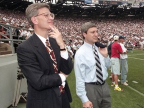 Penn State athletic director Tim Curley (L) and Penn State president Graham Spanier watch a football game from the sidelines at Beaver Stadium in State College, Pennsylvania in this September 9, 1995 file photo. Spanier will be charged with perjury and obstruction offenses for his alleged role in covering up the Jerry Sandusky child sex abuse scandal. (Craig Houtz/Files, Reuters)