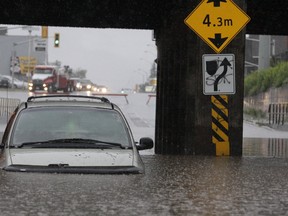 A mini-van is partly submerged in water at the underpass on Wellington Street last Friday evening as the area was hit with a major thunderstorm that dropped more than 50 mm of rain. Streets turned into rivers as the downfall temporarily overwhelmed local capacity to drain the water.