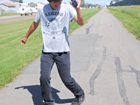 Sixteen-year-old Chris Amnesty twists his way down 92 Street on a sunny afternoon, Tuesday. Grande Prairie’s “Dancing Kid” has been inspiring others, uplifting his mood and creating new moves since 2010, when he first started grooving in the public arena. (Elizabeth McSheffrey/Daily Herald-Tribune)
