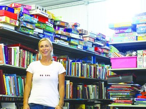JANE DEACON HIGH RIVER TIMES/QMI AGENCY Foothills Salvage and Recycling Centre manager Candice Dupre stands amid shelves of donations she has received over the last three weeks from communities across western Canada.