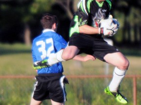 Quinte Old Boys goalkeeper J.F. Labonte leaps to grab a ball away from Azzurri forward Sean Fougere during the Azzurri's 3-2 Bay of Quinte Men's Soccer League First Division win last Thursday at Zwick's Park.
