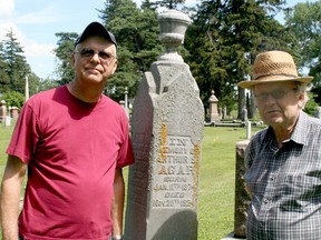 Paul Thorpe and John Skakel pose at the monument of Arthur S. Agar, who lived from Jan. 11, 1874 to Nov. 20, 1924. Volunteers repaired the vase-like portion at the top of the monument after it had broken off.