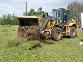 Construction crews strip the topsoil from the 108th Avenue property in preparation for land surveys before excavation on the basement can begin. Friday, July 26.