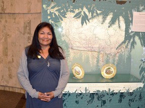 Judy Half, the Royal Alberta Museum’s aboriginal liaison officer, stands in front of two historic plates depicting the journey of Milton and Cheadle, possibly the first “tourists” in the local region. Half’s distant ancestors are depicted on one of the plates.