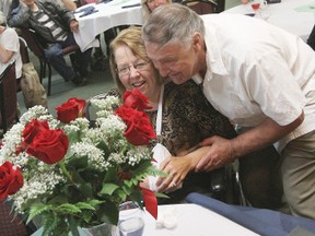 Ferdi Erhard presents his wife Joan with a bouquet of roses during the Florence Riske Caregiver Award presentations July 27.