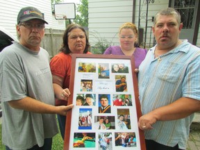 Holding a collection of photographs of the late Joshua Alderton are, from left, his step-father Len Parkin, mother Laurie Alderton, sister Shelbei Luther and father Rob Glendinning. Alderton's family and friends are holding a fundraiser Aug. 10 in Sarnia to establish a scholarship for women affected by family violence. Sarnia, Ont., July 31, 2013 (PAUL MORDEN, The Observer)