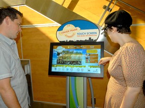 Marcus Vanstone, left, and Kelsey Sanderson check out the new information tourism kiosk at the Grande Prairie Airport. The kiosk, created and designed by Broca Media in partnership with the Grande Prairie Tourism Assocation can help map out distances to attractions, museums and events taking place in the area from the airport for arriving travellers. (Jocelyn Turner/Daily Herald-Tribune)