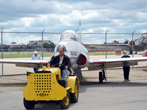 Tom Hinderks, executive director at the Alberta Aviation Museum, uses a cart to haul a jet back into the museum’s hangar. Photo by Doug Johnson/Edmonton Examiner