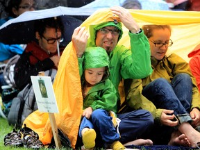 Attendees to the Interstellar Rodeo try to stay dry during the 2013 Interstellar Rodeo at Hawrelak Park. QMI Agency photo