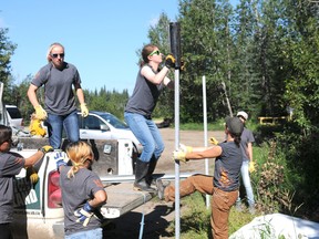 Junior Forest Ranger Grace Reichl drives a pole into the ground that will hold up a public bulletin in the Dunes recreation area, south of Grande Prairie, Wednesday. Reichl, along with several other JFR, spent the day near Grande Prairie taking care of natural and forested areas. (Aaron Hinks/Daily Herald-Tribune)