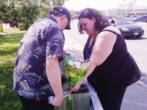 Grant and Becky of Blossom Park came equipped with duct tape to place flowers in memory of murder victim Melissa Richmond on Wednesday. Richmond, 28, of Winchester, was found  dead in a ditch bordering the South Keys Shopping Centre on July 28.
KELLY ROCHE//QMI AGENCY