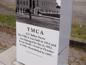 A photographic image of the former St. Thomas YMCA decorates a traffic signal controller box at the corner of Talbot and Ross streets where the building once stood on now-vacant land behind.