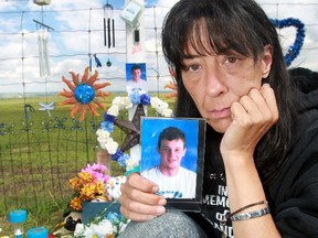 Devastated mom, Kim Thomas with a new roadside memorial for her son Brandon on Hwy. 22 just south of Cochrane after it was removed along with cherished belongings including numerous keepsakes. She is pleading to who ever took them to return them to the new roadside memorial.