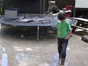 Willie Pentland sifts through the water left behind after the floods in Exshaw. His mother’s own campaign is aiming to raise $2 million.