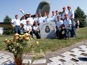 A group of search and rescue technicians from 424 Transport Search and Rescue Squadron at 8 Wing/CFB Trenton, Ont. pose for photographs along an Ad Astra stone commemorating the ultimate sacrifice made by 424's SAR Sgt. Janick Gilbert, 34 — who died during a rescue mission in Nunavut Oct. 27, 2011 — during the 17th annual Ad Astra ceremony held in the RCAF Memorial Airpark at the National Air Force Museum of Canada in Trenton, Ont. in August 2012. - JEROME LESSARD/The Intelligencer