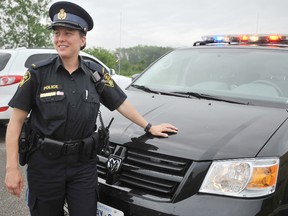 Ontario Provincial Police Const. Chrystal Jones stands by her vehicle as a driver passes in this 2011 file photo. OPP are reminding everyone to stay safe on roads and waterways this long weekend. THE OBSERVER/ QMI AGENCY