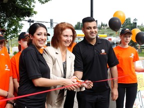 Jasmine Randhawa (left) and Zee Virani celebrate with Deputy-mayor Joann Churchill at the opening of Little Caesars on July 18.