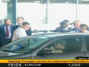 Fugitive former U.S. spy agency contractor Edward Snowden (C) talks with Russian lawyer Anatoly Kucherena (2nd R) in front of a car at Moscow's Sheremetyevo airport August 1, 2013 in this still handout image broadcasted by Rossiya 24 TV Channel. (REUTERS/Rossiya 24/Handout via Reuters)