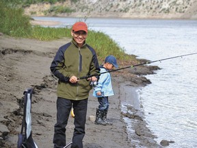 Michael Liu of Edmonton fished with his son on the banks of the North Saskatchewan River in Voyager Park on Saturday, July 27.