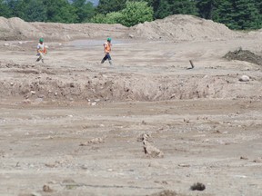 Workers walk across the site of the new St. Mary's College on Thursday