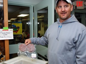 Doug Cumlin, of Minneapolis, Minn., checks out meats for sale at
the Johnson Farmers' Market.