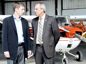 Colin Edwards, senior project developer for Pattern Energy, left, and Mayor Randy Hope, share a quiet word inside one of the Chatham-Kent Municipal Airport hangers after announcing the airport enhancements that will begin Tuesday thanks to a $2.5-million investment from the South Kent Wind Project, of which Pattern and Samsung Renewable Energy are partners in. The enhancements include adding 500-feet to the existing main runway, upgrading the lighting system and adding a precision approach path indicator system and automated weather station. (DIANA MARTIN, The Daily News)
