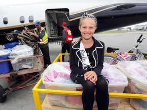 Little Miss Calgary, Grace Pound, supervises the unloading of a plane from North Cariboo Air that brought in flood relief supplies collected by the citizens of Beaumont, Alberta, for flood victims in Calgary and surrounding area to be distributed by NeighbourLink. They were at the North Cariboo Air headquarters in Calgary, Alberta, on July 25, 2013. Behind her unloading are North Cariboo Air ground crew Doug Raincock and Bobby Bogensberger. Mike Drew/Calgary Sun/QMI AGENCY