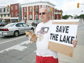 Ingersoll resident Ted Bowman holds his dog, Sari, and a "save the lake" sign on Charles Street in Ingersoll on Friday, Aug. 2, 2013, when several people opposed to Walker Environmental Group's proposal for a landfill in Zorra turned out to promote their message. JOHN TAPLEY/INGERSOLL TIMES/QMI AGENCY