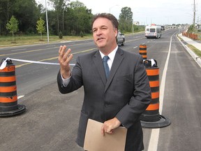 Leeds-Grenville MP Gord Brown, representing Denis Lebel, the minister of infrastructure, communities and inter-governmental affairs, addresses the gathering for the official re-opening of John Counter Boulevard Friday morning.