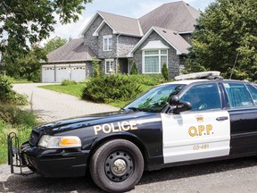 An O.P.P. cruiser sits outside of Melissa and Howard Richmond’s home outside of Winchester on Friday.
Errol McGihon/QMI Agency